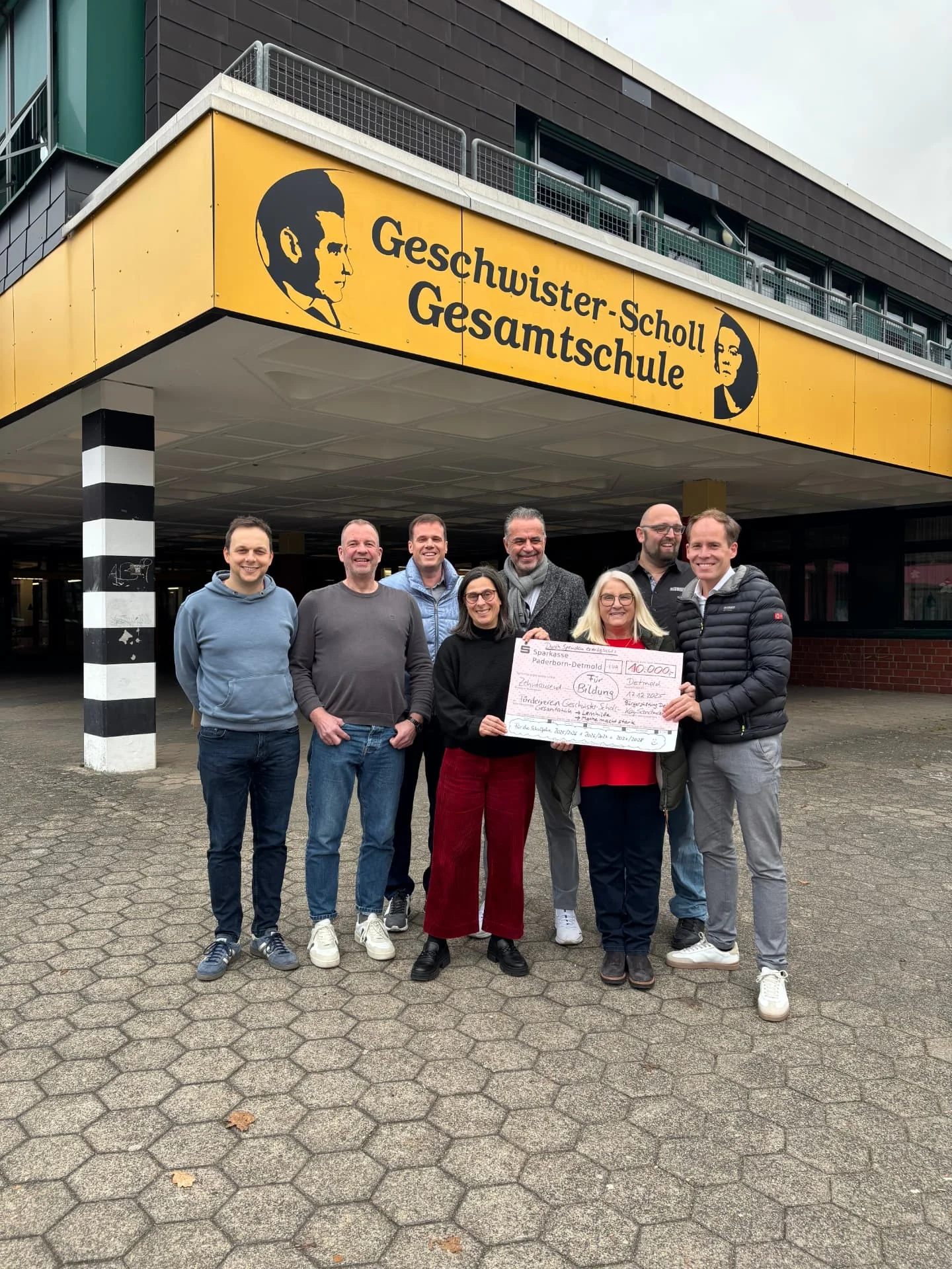 Spendenübergabe eines Schecks über 10.000 Euro für die Lernhilfe vor der Geschwister-Scholl-Gesamtschule