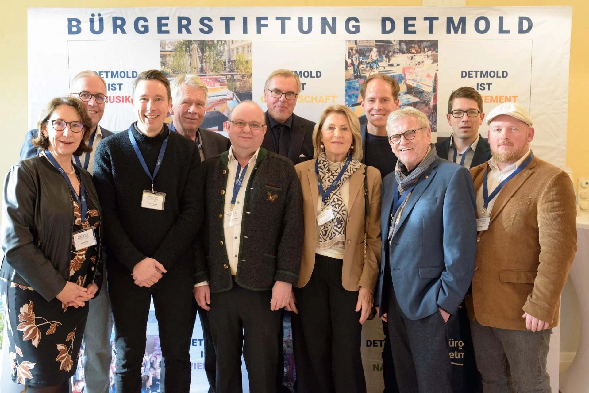 Gruppenfoto von Vorstand und Stiftungsrat der Bürgerstiftung Detmold vor der Präsentationswand beim Neujahrsempfang 2025.