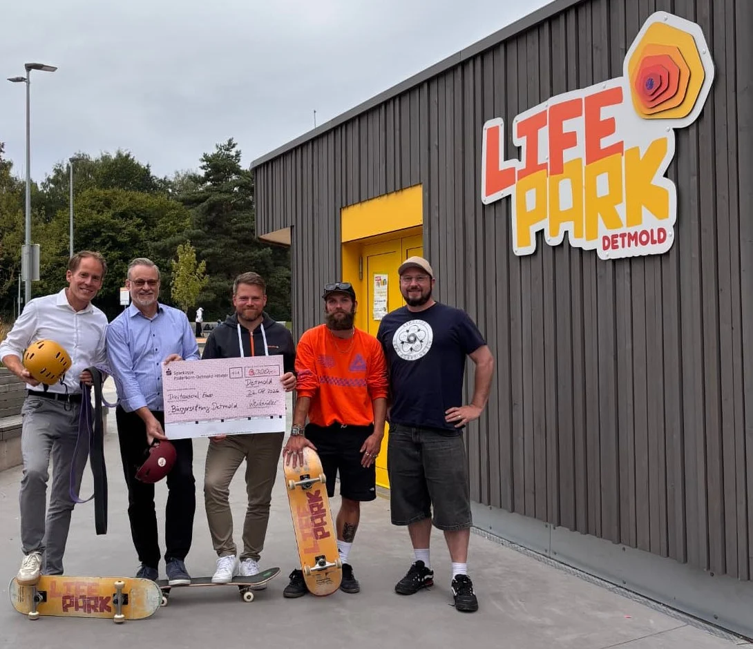 Scheckübergabe im Life Park Detmold: Vertreter von Weidmüller, Bürgerstiftung Detmold und LIPslide Skateboarding e.V. mit Skateboards vor dem Sport-Pavillon mit dem Life-Park-Logo.